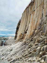 Rock formation on beach against sky