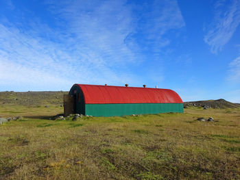 Built structure on field against blue sky