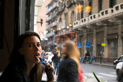 Young woman smoking cigarette in city