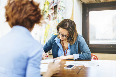 Focused mature businesswomen working in enterprise workshop