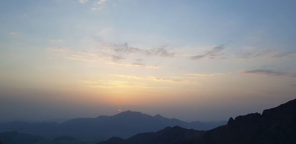 Scenic view of silhouette mountains against sky during sunset