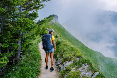 Rear view of man with arms outstretched against mountains