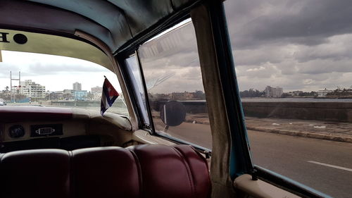 Close-up of cars against sky seen through car window