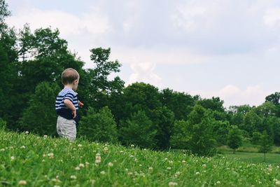 Boy on field against sky