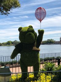 Teddy bear pattern hedge against lake in city