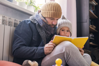 Young woman using digital tablet while sitting on sofa at home