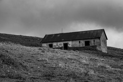 Abandoned house on field against sky