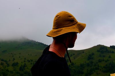 Rear view of man looking at mountain against sky