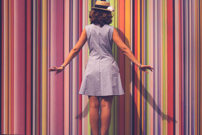 Rear view of a woman with multi colored curtain