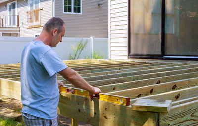 Side view of man standing against building