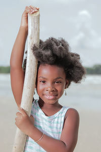 Portrait of smiling girl standing against tree