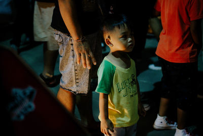 Thoughtful boy standing with family at home