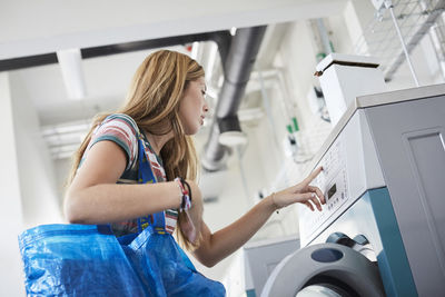 Low angle view of woman using washing machine