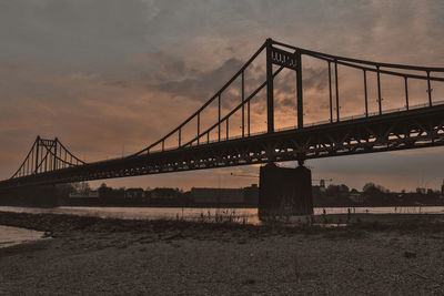 View of suspension bridge against cloudy sky