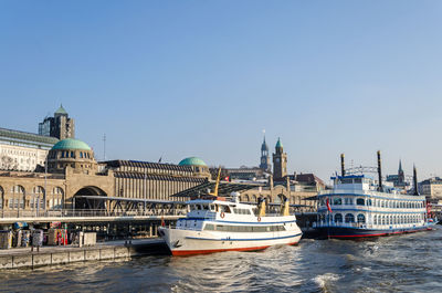 View of boats in city against clear sky