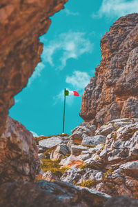 Low angle view of italian flag on mountain against sky