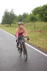 African woman cycling by the beach on a mountain bike