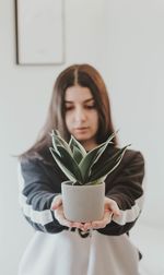 Young woman reading book against wall