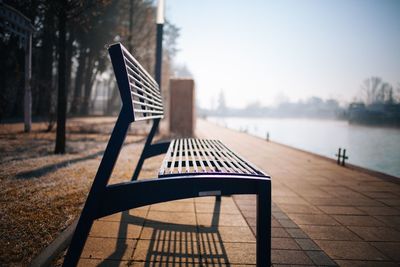 Close-up of wooden seat against sky