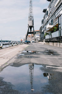 Crane reflection in puddle at parking lot