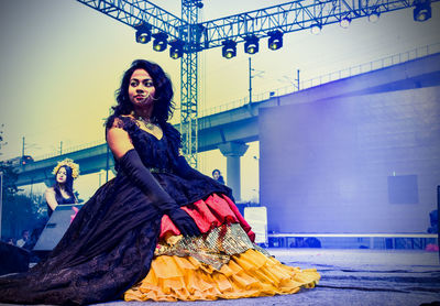 Full length portrait of young woman standing outdoors