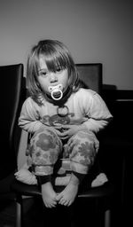 Full length of girl sitting on chair