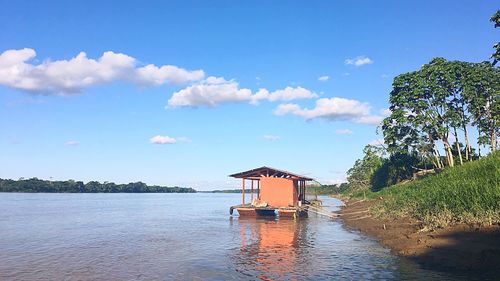 Building by river against sky