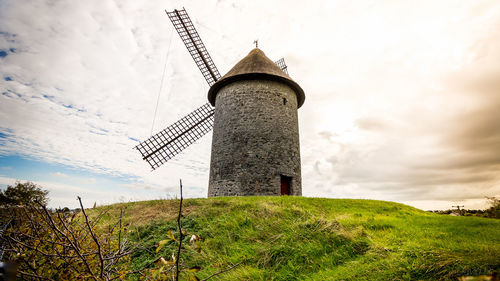 Low angle view of tower on field against sky