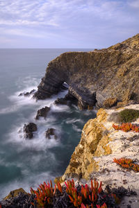 Scenic view of rocks on beach against sky