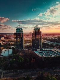 Buildings in city against sky during sunset