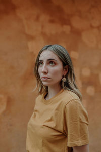 Portrait of a young woman against wall