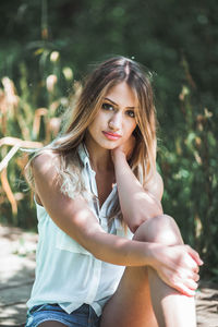 Portrait of beautiful young woman sitting outdoors