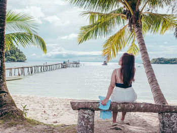 Rear view of woman looking at sea against sky