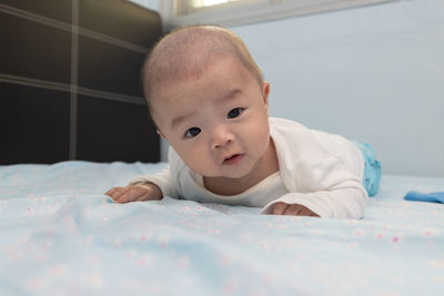 Portrait of cute baby lying on bed