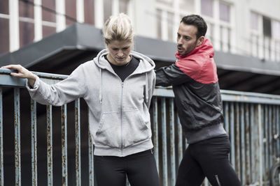 Sporty couple in jacket by railings