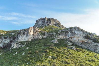 Low angle view of rocks on mountain against sky