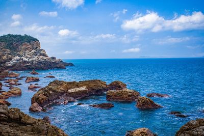 Scenic view of rocks in sea against sky