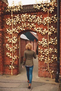 Rear view of woman walking towards decorated archway