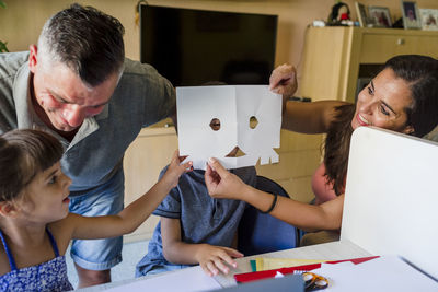 Family with children doing homework at home