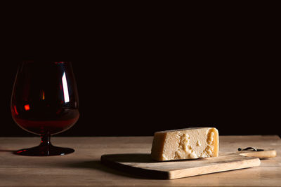 Close-up of wineglass on table against black background