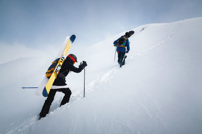 Backcountry climbers walking with skis in the mountains. ski tourism in alpine landscape with snowy