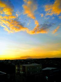 Aerial view of buildings against sky during sunset