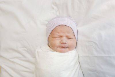 High angle view of baby sleeping on bed