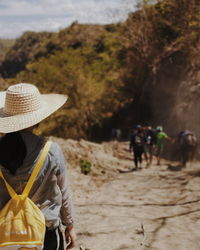 Rear view of people walking on land