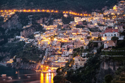 Illuminated buildings on mountain at positano