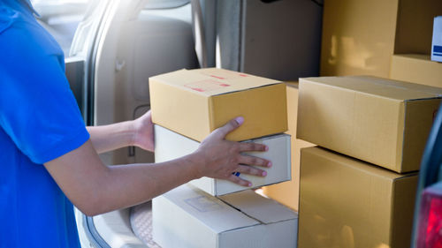 Midsection of woman holding camera in box