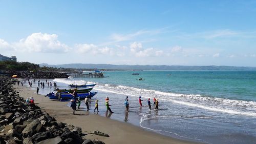 People on beach against sky