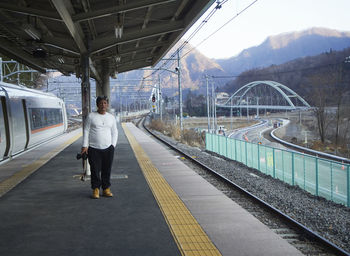 Rear view of man standing on railroad station platform