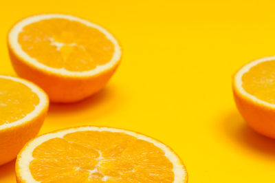 Close-up of orange fruits over colored background