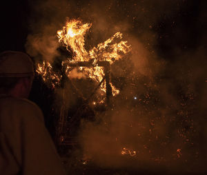 Rear view of man with fire crackers at night